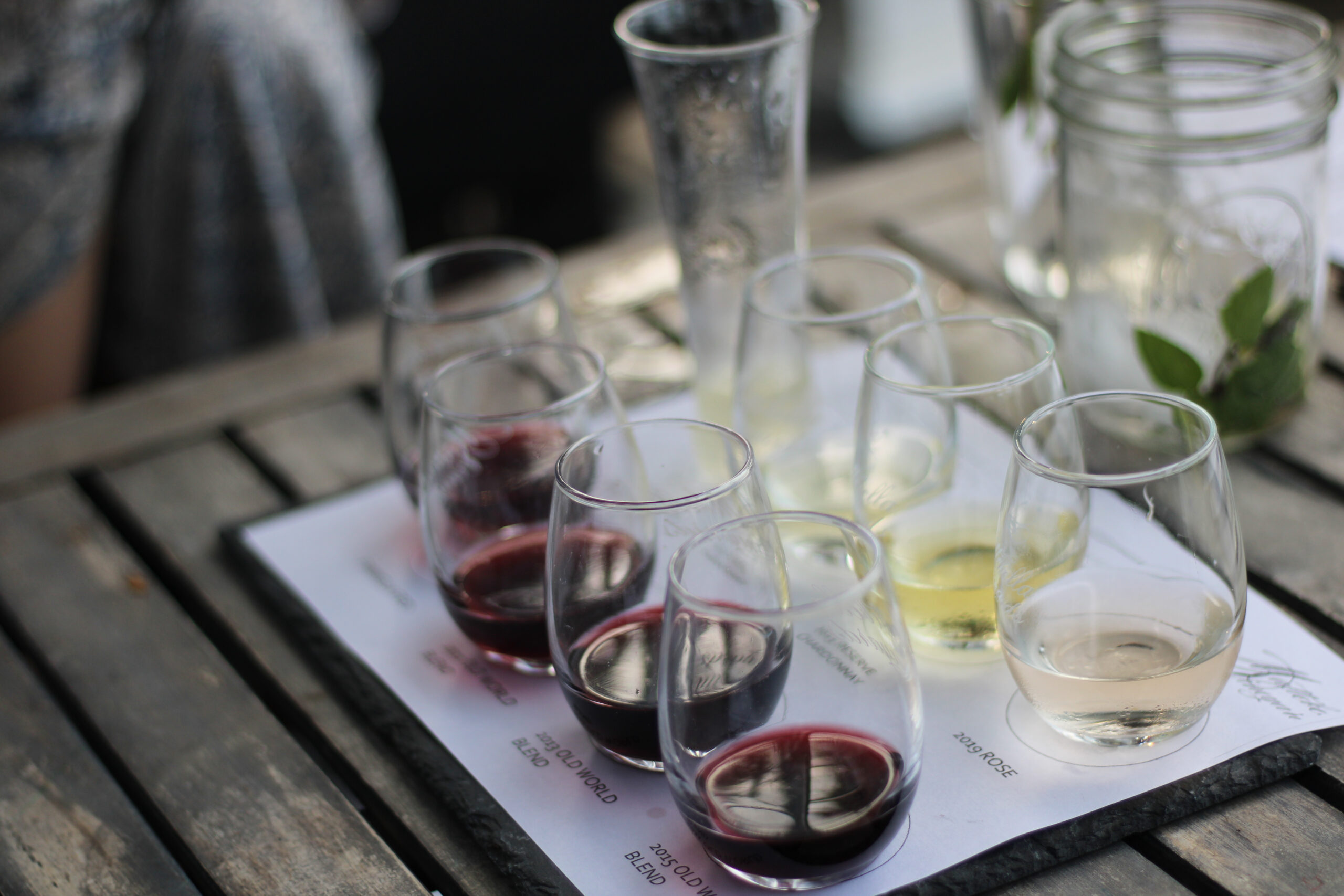 Wine flight presentation with glasses on wooden board
